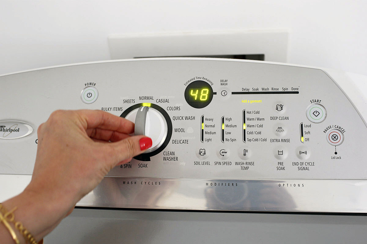 hand changing washing machine dial