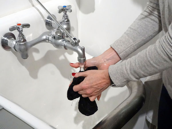 A pair of tights being washed using The Laundress's method to clean & preserve black tights.